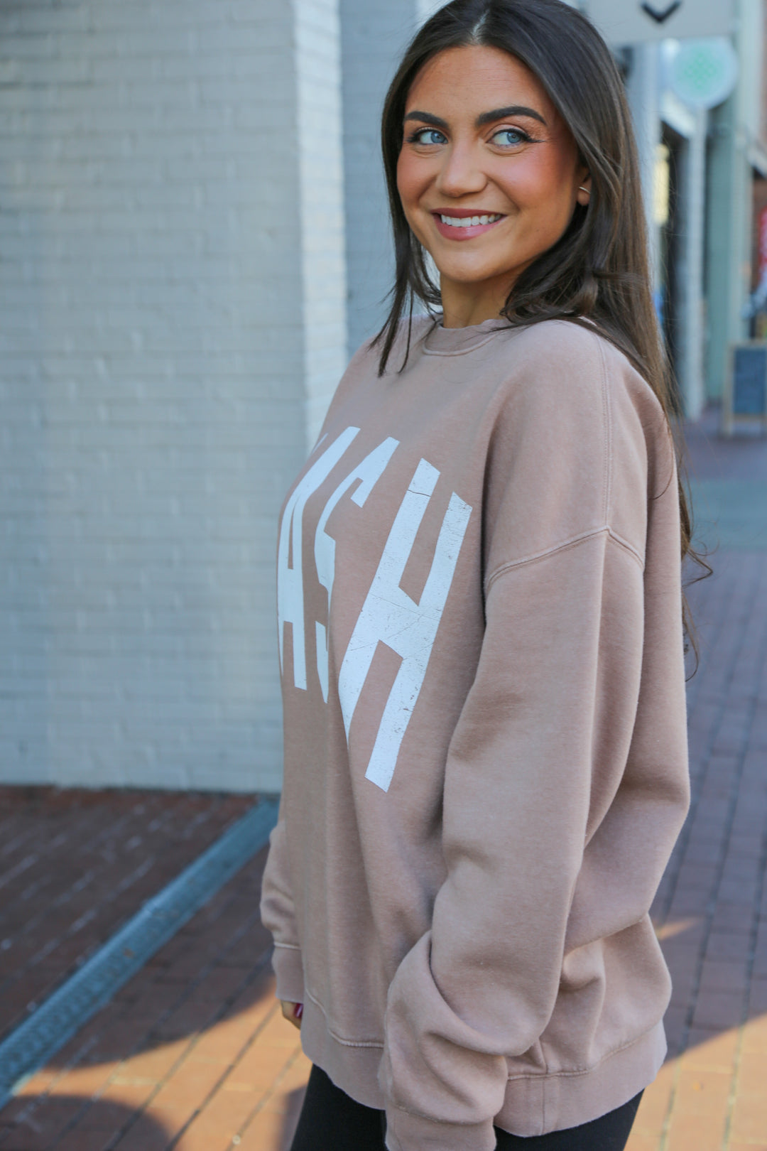 Side view of the light Tan/Taupe oversized vintage wash crewneck with oversized ‘nash’ screen printed on the front 