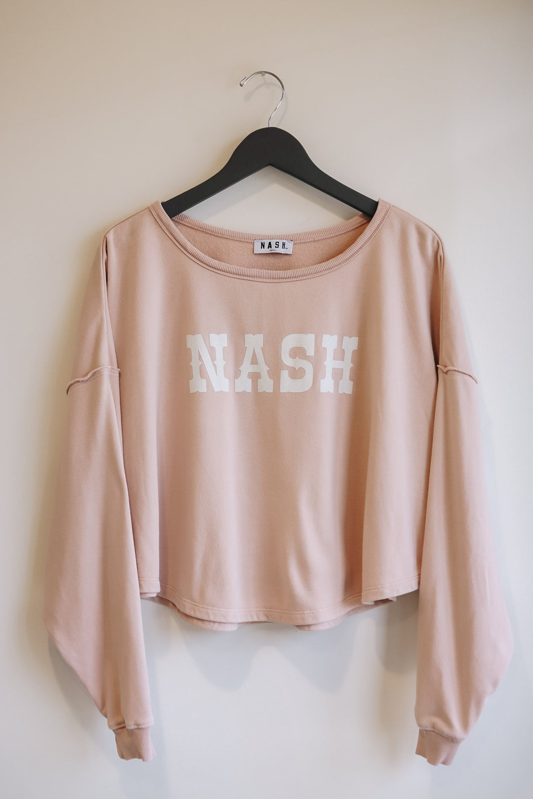 NASH in a western font on the boxy boatneck crewneck