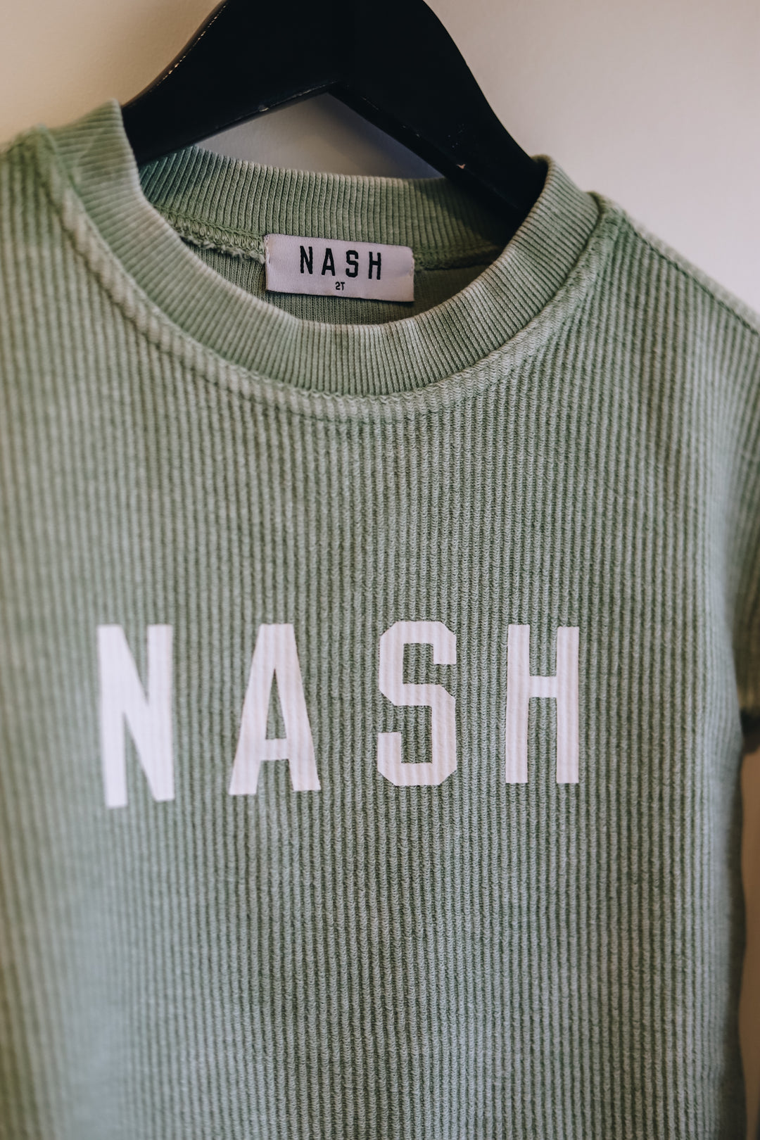 Up close view of the NASH screen printed on the front of kids corded crew