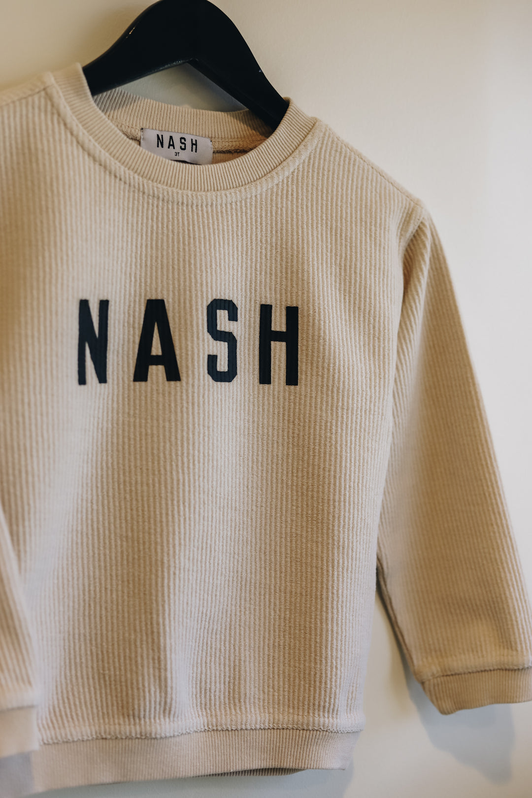 Up close view of the NASH screen printed on the front of kids corded crew
