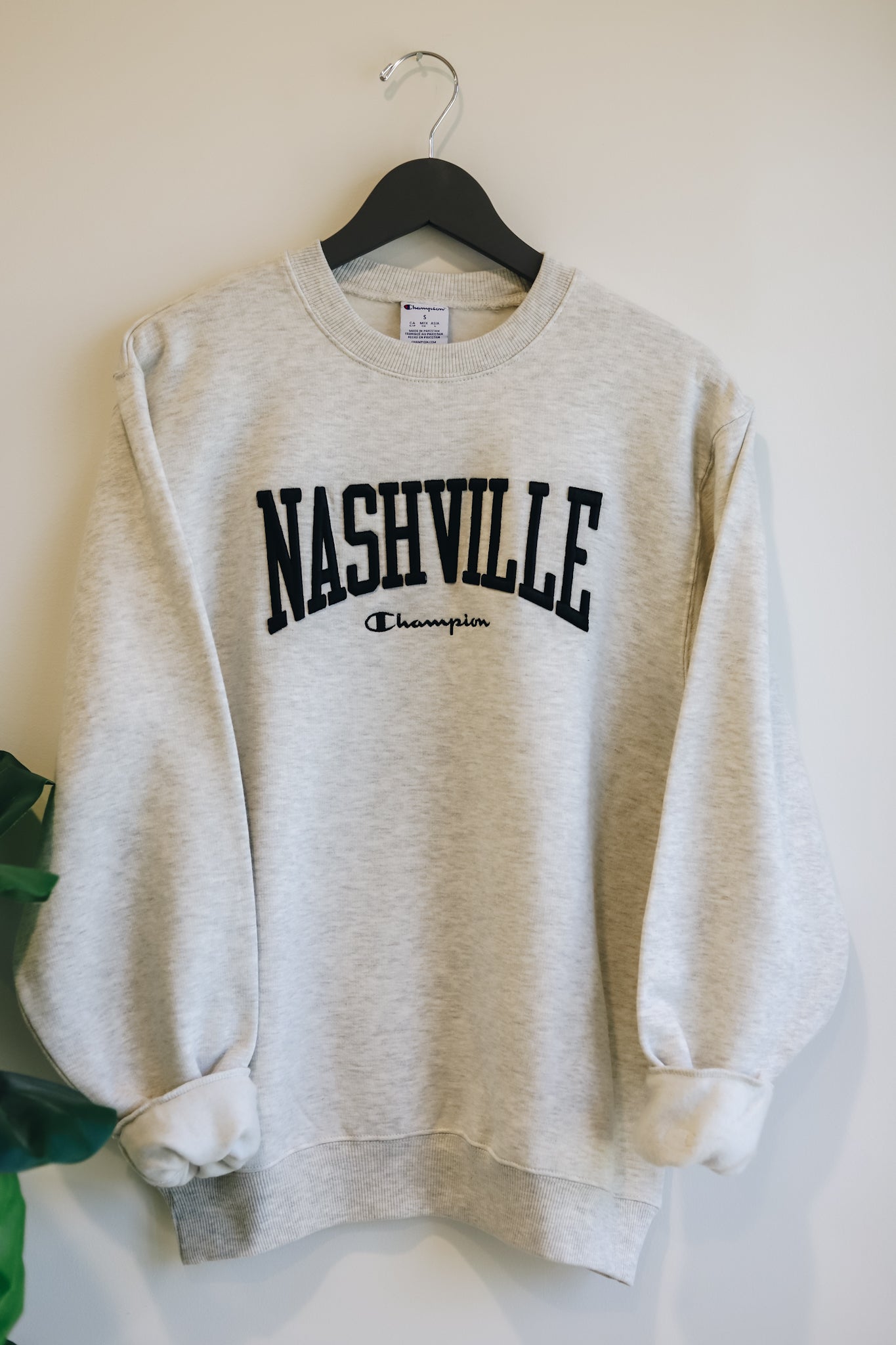 Hanging photo of oatmeal champion powerblend with black 3d embroidered Nashville across the chest. 
