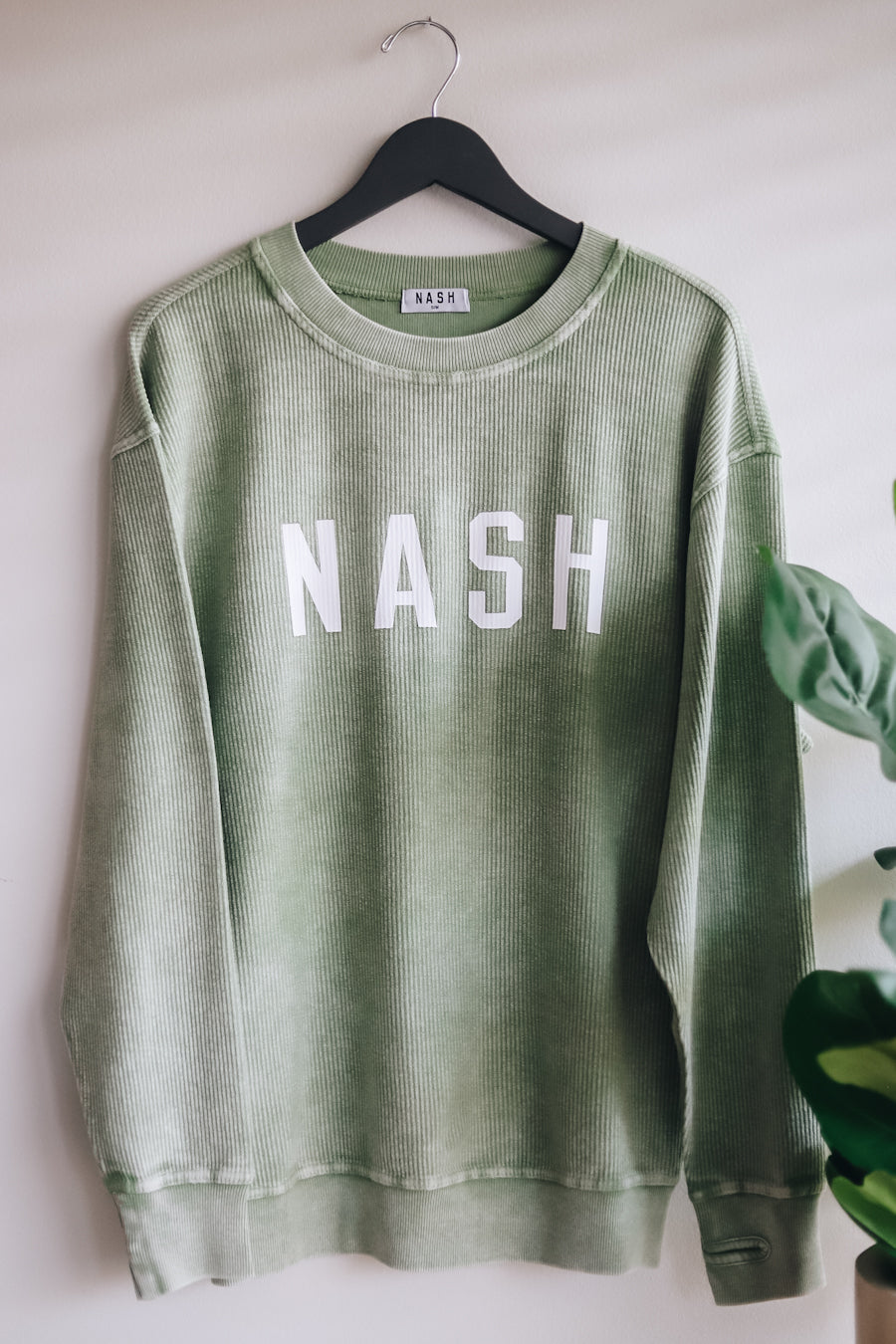 Front view of the spring green corded crewneck with NASH in the front 